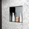 Here's an alt tag for the image: Shower niche with shampoo and conditioner.