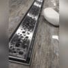 Linear shower drain with water droplets.