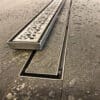 Stainless steel linear shower drain installation.